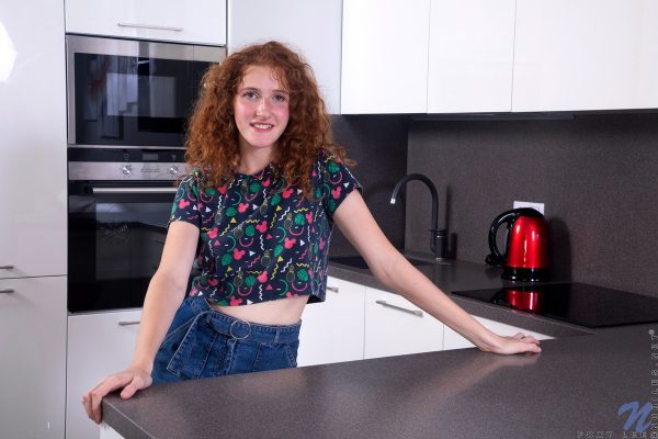 Девушка-подросток соло Фокси Ли щеголяет кудрявыми рыжими волосами, раздеваясь на кухне