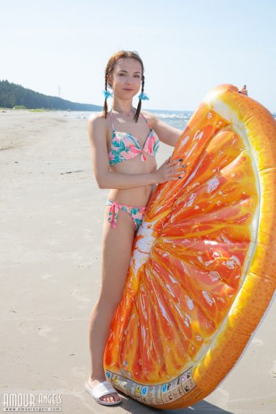 Молодая девушка Нэсти снимает бикини, чтобы позировать обнаженной с заплетенными косичками на пляже