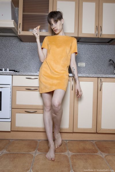 Коротко стриженная девушка Мелинда демонстрирует свои волосатые подмышки и кусты на кухне