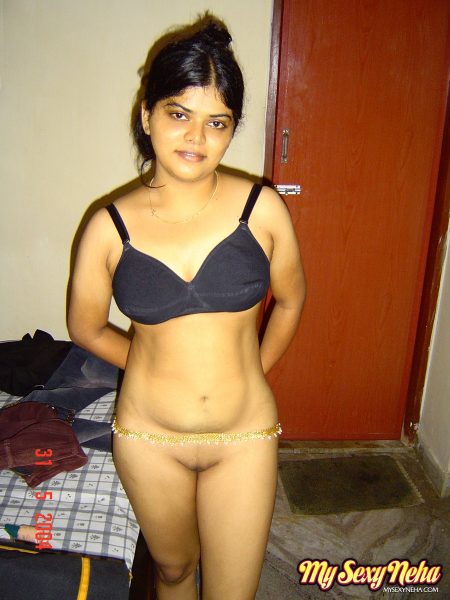 Индийская сольная девушка Неха стоит совершенно голая после раздевания в спальне
