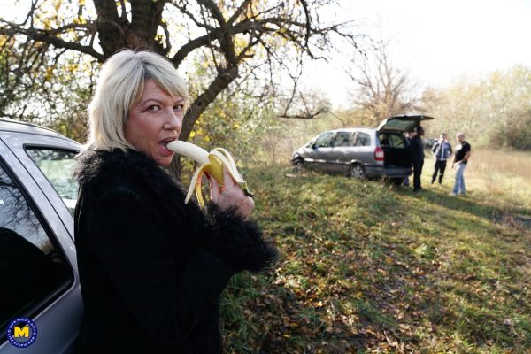 Зрелая блондинка ест банан перед групповухой в сельской местности