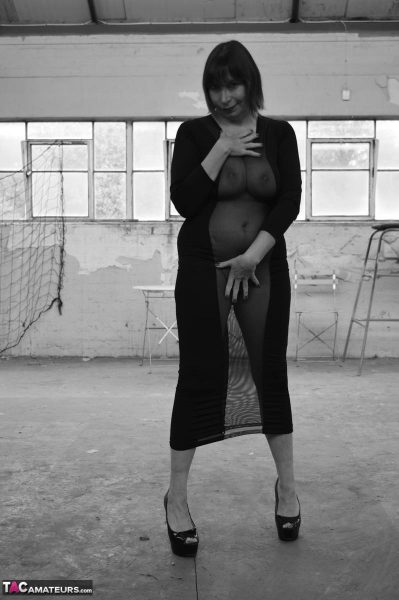 Женщина средних лет, Барби шлюха, моделирует прозрачное платье для черно-белого концерта