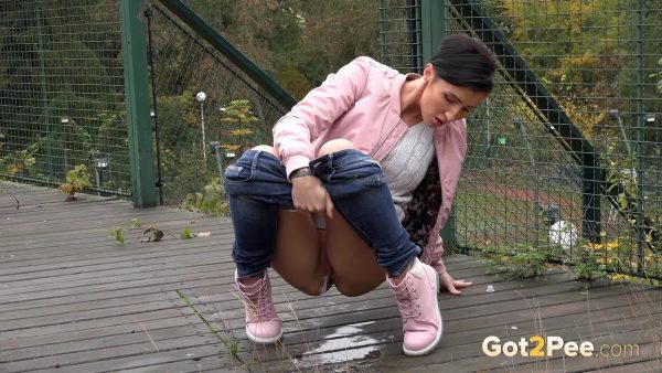 Коротко стриженная женщина Габриэлла Гуччи приседает на корточки, чтобы попрыгать на общественном кроссовере