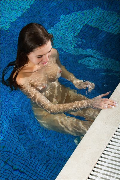 Горячая модель брюнетка плавает обнаженной в бассейне и показывает свою голую киску крупным планом