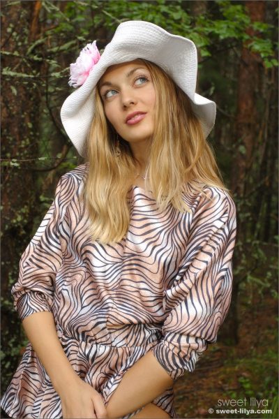 Симпатичная блондинка Сладкая Лиля приподнимает платье для сексуальной юбки в лесу