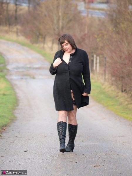 Женщина с избыточным весом Рокси обнажает себя, идя по дорожке в черных сапогах