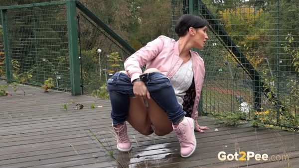 Коротко стриженная женщина Габриэлла Гуччи приседает на корточки, чтобы попрыгать на общественном кроссовере