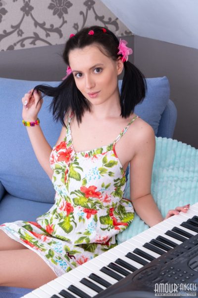 Молоденькая девушка Минни раздевается с косичками пока играет на клавиатуре