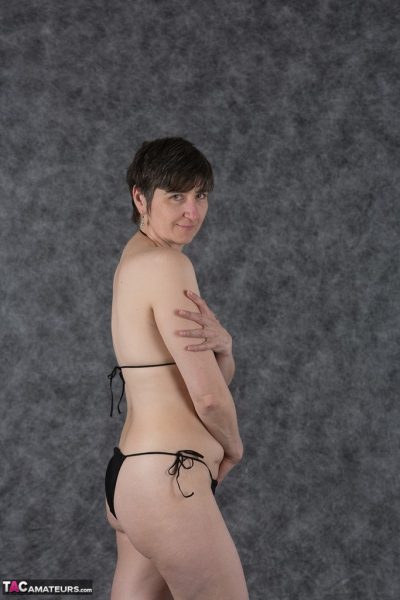 Любительница с короткой стрижкой держит свои сиськи после снятия черного бикини