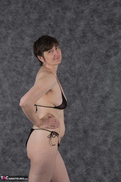 Любительница с короткой стрижкой держит свои сиськи после снятия черного бикини
