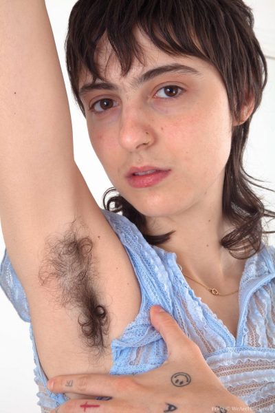 Татуированная девушка с пушистыми подмышками растягивает свою действительно волосатую пизду